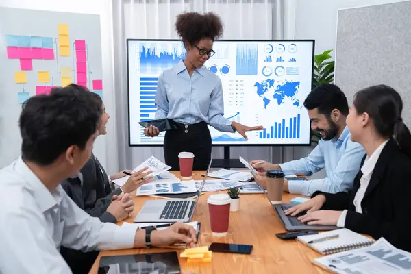 Genç Afrikalı iş kadını modern toplantıda TV ekranında veri analizi paneli sunuyor. Bir grup iş adamıyla konferans odasında iş sunumu. Uyum