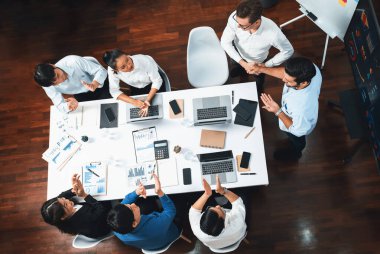 Üst düzey ofis çalışanları stratejik iş pazarlama toplantısı üzerine anlaşma yaptıktan sonra el sıkışıyor. Takım çalışması ve olumlu tutum verimli ve destekleyici bir iş yeri yaratır. Tedbirli