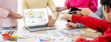 İç mimar ekibinin kırpılmış görüntüsü materyal rengini tartışırken, dizüstü bilgisayar cep telefonu uygulaması ve web sitesi için web sitesi kablo tasarımı görüntülendi. Yaratıcı tasarım ve iş konsepti. Değiştirilmiş.