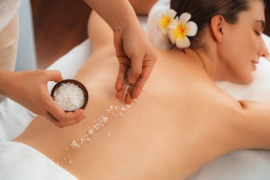Lüks spa salonlarında sıcak mum ışığında cilt bakımı yaptıran kadın müşteri. Sağlık Spa vücut fırçasında tuz temizleme güzellik tedavisi. Sessiz.