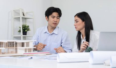 Kooperatif mühendis ekibinin portresi ev modelini ölçmek için cetvel ve mimari ekipmanlar kullanarak birlikte çalışıyor. Yaratıcı iş tasarımı ve takım çalışması konsepti. Tertemiz...