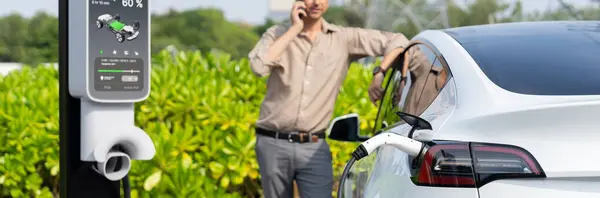 Mann Telefoniert Beim Aufladen Der Elektroauto Batterie Einer Ladestation Die — Stockfoto
