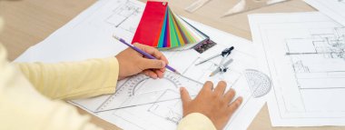 Proje yöneticisi hata noktasını mimari belge, renk paleti dağınıklığı ile gösterirken, profesyonel mimar elin kırpılmış görüntüsü plan çizer. - Yakın çekim. Değiştirilmiş.