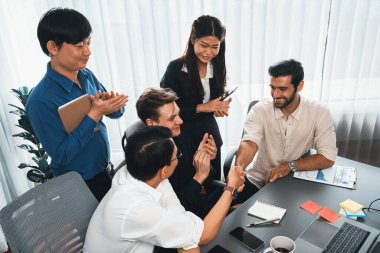 Çeşitli ofis çalışanları stratejik iş pazarlama toplantısı üzerine anlaşma yaptıktan sonra el sıkışıyor. Takım çalışması ve olumlu tutum verimli ve destekleyici bir iş yeri yaratır. Tedbirli