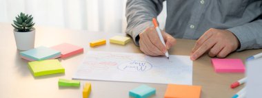 Yetenekli iş adamları zihin haritaları kullanarak pazarlama fikirleri üretiyor. Başarılı erkek girişim lideri masaya yapış yapış notlar serpiştirerek finansal plan hazırlıyor. - Yakın çekim. Eline odaklan. Değişik..