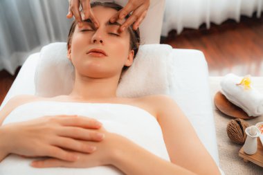 Kafkasyalı kadın stres önleyici kafa masajından ve lüks tatil beldesi ya da otel spa salonundaki modern ışık ortamında yüz güzelliği eğlencelerini şımartmaktan hoşlanıyor. Sessiz.