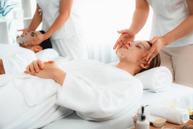 Kaplıca salonunun sakin, modern gündüz atmosferi, birkaç müşteri yüz maskesi takarak kendini yenilemeye çalışıyor. Yüz bakımı ve güzellik kozmetolojisi prosedürü. Sessiz.