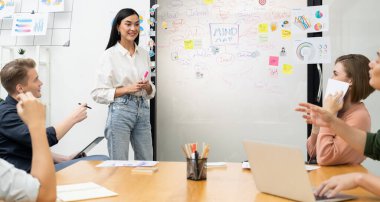 Genç ve güzel lider pazarlama stratejisini sunarken, uzman yatırımcı ve proje yöneticisi de yeni başlayan iş toplantısında iş performansını analiz etmeye çalışıyor. Çok ırklı bir grup. Tertemiz..