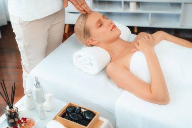 Kafkasyalı kadın stres önleyici kafa masajından ve lüks tatil beldesi ya da otel spa salonundaki modern ışık ortamında yüz güzelliği eğlencelerini şımartmaktan hoşlanıyor. Sessiz.