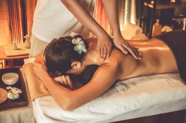 Beyaz kadın müşteri stres önleyici spa masajının keyfini çıkarıyor ve lüks otel ya da otelde sıcak mum ışığında güzellik teniyle eğleniyor. Sessiz.