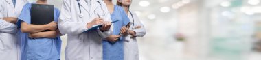 Doktor hemşiresi ve sağlık uzmanı olan kendine güvenen tıbbi ekip bulanık hastane koridorundaki insanları mesleklerine yönlendiriyor. Panoramik pankartta tıbbi ve sağlık hizmetleri topluluğu. Neoterik