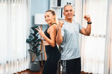 Sportif ve sportif son sınıf çifti portresi. Spor kıyafetleri içinde. Emeklilikten sonra sağlıklı vücut yaşam tarzına sahip ev egzersizi konsepti olarak mücadele duruşunu aştıktan sonra veya başarılı bir şekilde kutlandıktan sonra. Etki