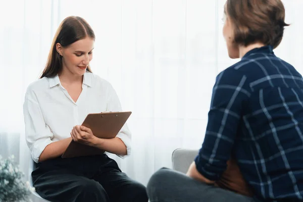 Happy patient and psychologist have mental health conversation in clinic with positive emotion while explaining utmost successful work and life to psychologist in home office .