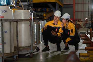 İki fabrika işçisi veya mühendis, kimya fabrikası, kimya fabrikası işyeri ve endüstriyel meslek konseptinde makine veya prosedür üzerinde profesyonel teftiş yürütüyor. Örnek gösteriliyor