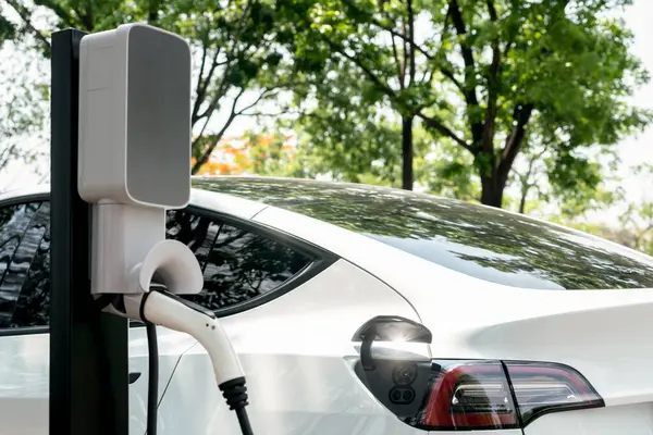 EV elektrikli araç EV şarj istasyonu ulusal park veya açık hava orman manzaralı. Çevre dostu EV arabalarla yaz ormanlarında doğal koruma. Yükselt