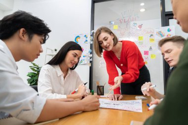 Genç ve güzel proje yöneticisi iş toplantısının önemli noktasını işaret ederken zihin haritası ve grafik grafiği kullanarak yaratıcı mutlu iş adamları beyin fırtınası ve paylaşım fikri. Tertemiz..