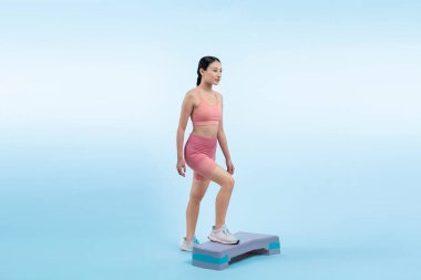 Çalışkan, enerjik bir kadın atölyede egzersiz yapıyor. Kardiyo aerobik hareketleriyle izole bir arka plan. Genç atletik Asyalı kadın mahareti ve dayanıklılık eğitimi konsepti.