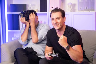 Kazanan ve kaybeden arkadaş oyuncular televizyonda video oyunu oynuyorlar. Stüdyo odasında neon mavi ışıklı joystickler kullanıyorlar. Memlekette rahat bir yaşam ve neşeli bir dövüş kazananı. Satılabilir.