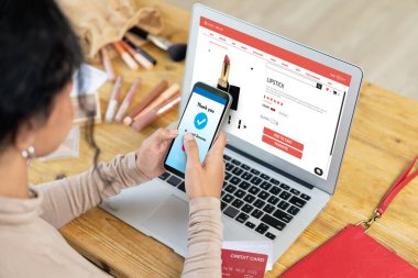 İnternet pazarından alışveriş yapan kadın modern yaşam tarzı için satış malzemeleri arıyor ve önemli siber güvenlik yazılımları tarafından korunan cüzdandan çevrimiçi ödeme için kredi kartı kullanıyor