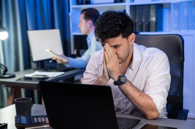 Baş ağrısı olan stresli iş arkadaşı gece vakti yeni bir proje üzerinde çalışıyor, e-posta bekliyor kazanma teklifi veren müşteri firması için geri gönderiliyor. Neon mavi ışık modern ofis üzerinde çalışma kavramı. Satılabilir.