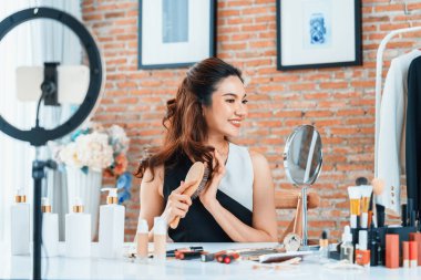 Kadın Etkilenen Vlog video görüntülerini canlı olarak çekiyor. Makyajın çoğu sosyal medya ya da blog 'u anlatıyor. Kozmetik stüdyosu ışıklandırmalı mutlu genç kız çevrimiçi pazarlama oturumu yayını için..