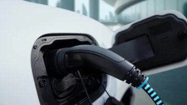 Elektrik yükleme istasyonundan elektrik yüklemek için elektrikli arabaya EV şarj prizi takın. Akıllı dijital batarya durum hologramı görüntüleyin. Geleceğin yeniliği ve yeşil enerji sürdürülebilirliği. İncelenme