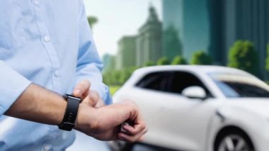 İş adamı, ESG yeşil parktan akıllı saat hologram şarj şarjının EV araba aküsü durumunu kontrol et. Modern şehir yaşam tarzı ve karbondioksiti azaltmak için çevre dostu elektrikli araba kullanımı. İnceleyin