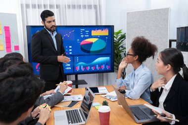 Pazarlama stratejisi için modern toplantıda veri analizi paneli ekranında sunan bir işadamı. Bir grup iş adamıyla konferans odasında iş sunumu. Uyum