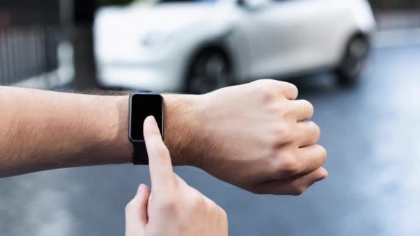 Affärsman Kontrollera Bilbatteristatus Smartwatch Skärmen Medan Laddar Från Laddstationen Stadsparkering — Stockvideo