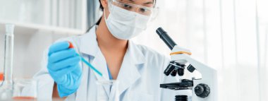 Laboratuvar araştırmacısı laboratuvar tüpünde kimyasal sıvı kullanarak yeni ilaç ya da tedavi geliştirir. Laboratuvar ekipmanları ile bilimsel uzmanlık ile sağlık hizmetlerinin teknolojik gelişimi. Panorama Katı