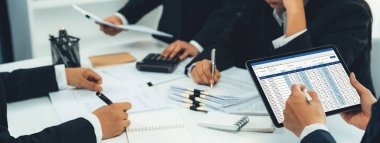 Şirket muhasebeci takımı, mali verilere dayanarak vergi iadelerini hesaplamak ve azami düzeyde tutmak ve finansal performansı artırmak için tablet üzerinde muhasebe yazılımı kullanır. Modern iş muhasebe konsepti. Kurnaz.