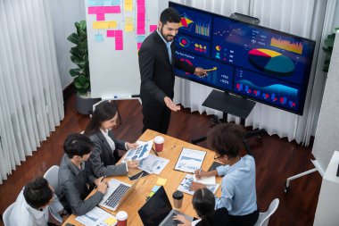 Pazarlama stratejisi için modern toplantıda veri analizi paneli ekranında sunan bir işadamı. Bir grup iş adamıyla konferans odasında iş sunumu. Uyum