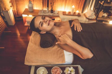 Beyaz kadın müşteri stres önleyici spa masajının keyfini çıkarıyor ve lüks otel ya da otelde sıcak mum ışığında güzellik teniyle eğleniyor. Sessiz.