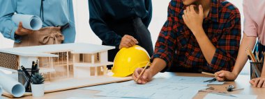 Becerikli mimar takımının tasviri, Mimarlık projesini ev modelleri ve mimari ekipmanlarla toplantı masasında tartışıyor. Yaratıcı tasarım konsepti. - Yakın çekim. Filizlenen.