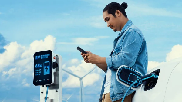 Asian Man Using Smartphone While Electric Car Recharging Energy Charger — Stock Photo, Image