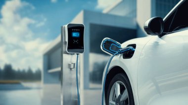 Gelecekteki mimari yapı arka planına sahip şarj istasyonuna bağlı yenilikçi elektrikli araba. Alternatif temiz ve sürdürülebilir enerji kullanan teknolojik gelişim şarj edilebilir EV araba. İnceleyin