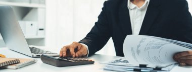 Şirket muhasebecisi, mali veri raporuna dayanarak vergi iadelerini hesaplamak ve en yüksek seviyeye çıkarmak ve finansal performansı artırmak için hesap makinesi kullanır. Panorama 'daki modern muhasebe. Kurnaz.