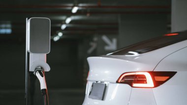 Alış veriş merkezinin otoparkında EV elektrikli araba şarjı şehir merkezindeki sürdürülebilirlik yaşam tarzını yeşil, temiz, yeniden şarj edilebilir elektrikli araç iç organları ile gösteriyor.