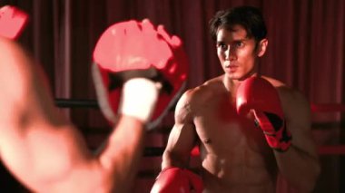Asyalı ve Kafkasyalı Muay Thai boksörü boks antrenmanında boks antrenmanında boks antrenörüne yumruk atma, Muay Thai boks tekniği ve becerilerini sergileme. Impetus
