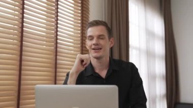 Genç adam internet bankacılığı için kredi kartlı dizüstü bilgisayar kullanıyor. İnternet üzerinden alışveriş yapıyor. Banka kartıyla modern ve kullanışlı online satın alma. Düzenle