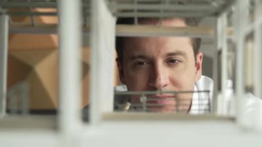 Kafkasyalı mimar mühendisinin yakın çekimi ev inşaatını denetlemek ve bina malzemelerini kontrol etmek. Proje yöneticisi modele dikkatlice bakarken kalemi işaret ediyor. Yönlendirici.