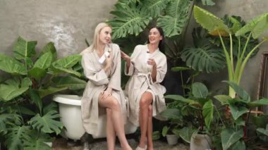 Modern otelde küveti olan tropikal ve egzotik bir spa bahçesi mi yoksa elinde bornozla gezen iki kadın mı yeşil yapraklı, boş zamanların tadını çıkarıyor? Blithe