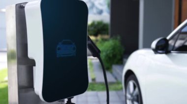 Fütürist EV şarj cihazıyla elektrikli araba şarj istasyonundan şarj oluyor. EV arabaların son teknoloji gelişimi ve sürdürülebilir enerji için akıllı ev yenilenebilir enerji altyapısı. İnceleyin