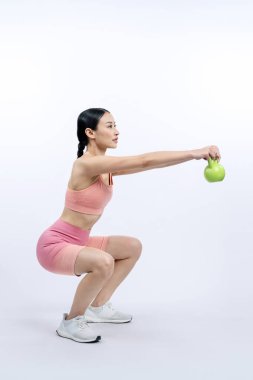 Dinç, enerjik bir kadın izole edilmiş arka planda ağırlık kaldırma egzersizi yapıyor. Genç atletik Asyalı kadın dayanıklılığı ve dayanıklılık eğitimi rutin vücut egzersizi..