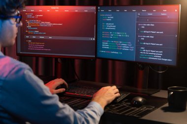 Uygulama pc ekranları ile çevrili çevrimiçi yazılım geliştirme bilgilerini yoğunlaştıran IT geliştiricisi, neon modern ofis evindeki web sitesinde yazılım için program yaratıyor. Toplayıcı.