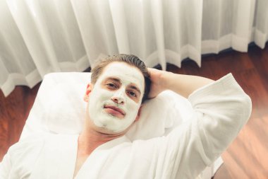 Kaplıca salonunun sakin atmosferi, insan müşterisi modern gün ışığında lüks yüz kremi masajıyla kendini yenileme zevkine kapılıyor. Yüz bakımı ve güzellik konsepti. Sessiz.