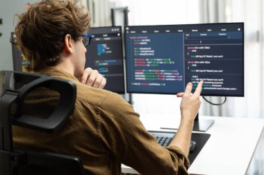 Bilgisayar ekranında çevrimiçi yazılım geliştirme kodlaması oluşturma konusunda stresli bir şekilde çalışan IT geliştiricisi, modern ofisteki web sitesi projesinde en son sürüm uygulaması için düşünme programı. Toplayıcı.