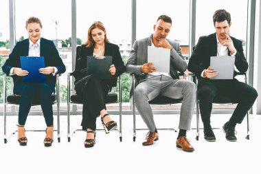 İş kadınları ve iş adamları iş görüşmesi için koltuklarda beklerken CV dosyasına devam ediyorlar. Şirket işi ve insan kaynakları kavramı. uds