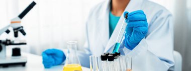 Laboratuvar araştırmacısı laboratuvar tüpünde kimyasal sıvı kullanarak yeni ilaç ya da tedavi geliştirir. Laboratuvar ekipmanları ile bilimsel uzmanlık ile sağlık hizmetlerinin teknolojik gelişimi. Panorama Katı