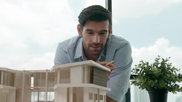 聪明的高加索工程师或项目经理站在城市全景窗前 俯瞰摩天大楼时 查看房屋模型 经理设计房屋的建造 小道消息 — 图库视频影像